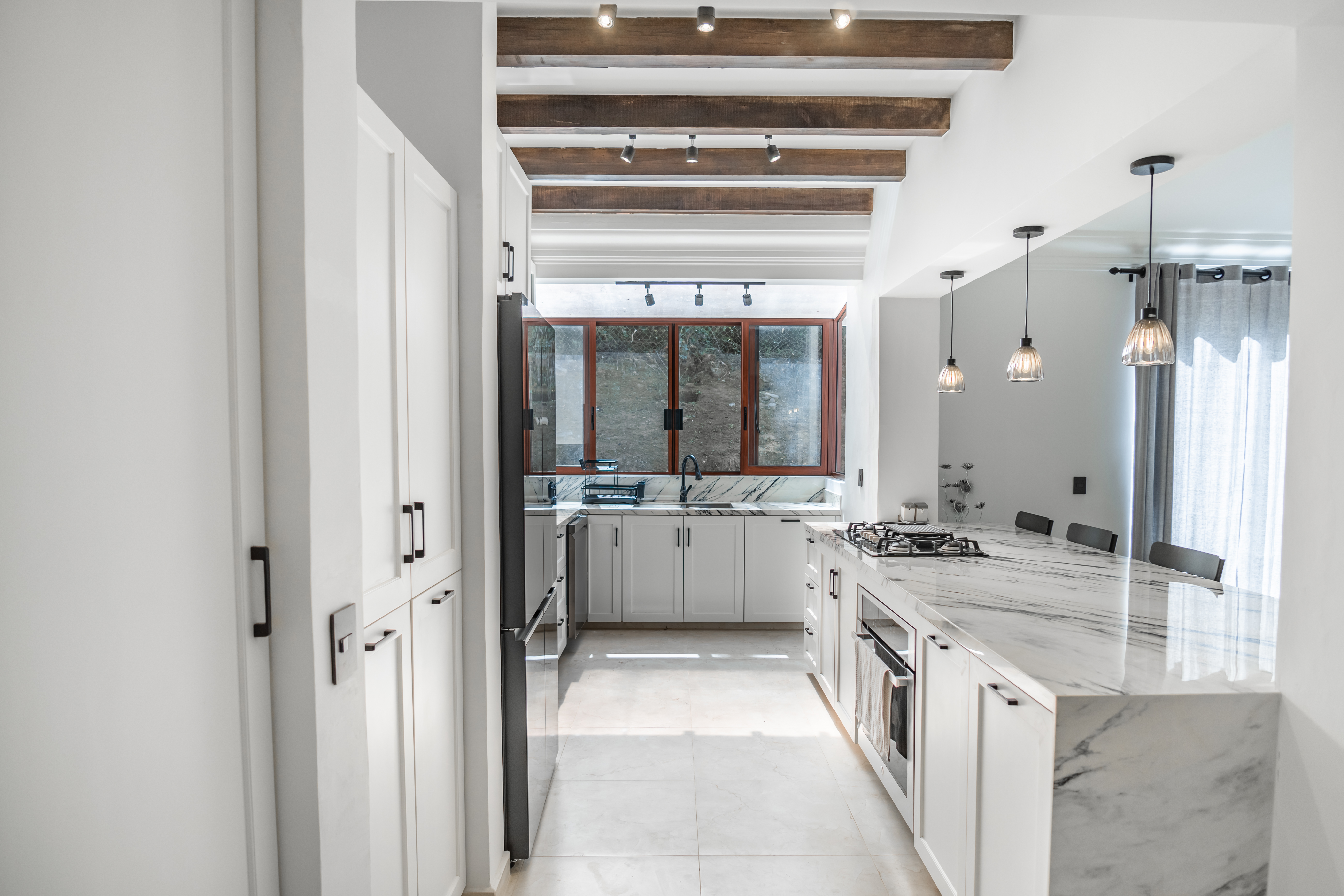 Cocina con mármol y vigas